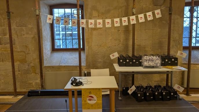 Abschlussveranstaltung Heiss auf Lesen 2025 Tisch mit Überaschungstüten + Rednertisch