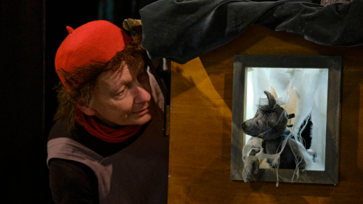 Ein Schausteller interagiert mit seiner Wolfspuppe.
