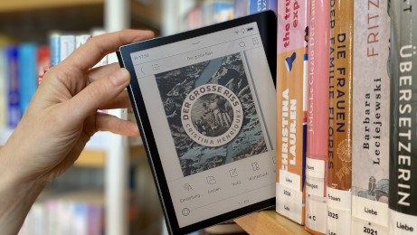E-Book-Reader wird aus einer Reihe von Büchern aus dem Regal gezogen