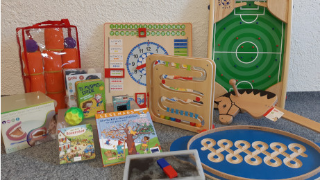 Spielsachen liegen vor einer Wand auf dem Boden
