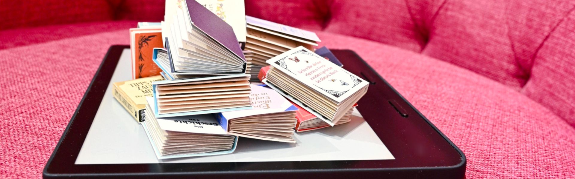Minibücher liegen auf einem eBook-Reader