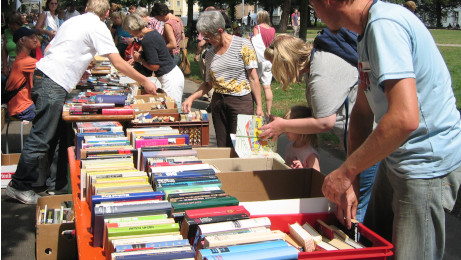 Menschen stöbern in Bücherkisten